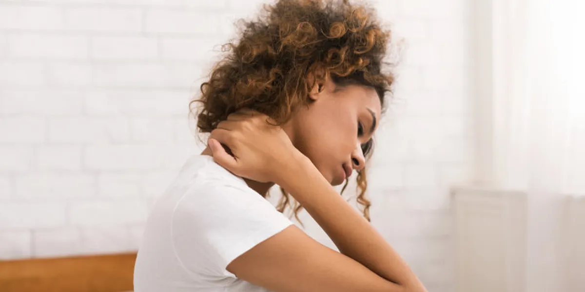 woman suffering from neck pain, waking up in the morning, sitting on bed woman suffering from neck pain, waking up in the morning, sitting on bed