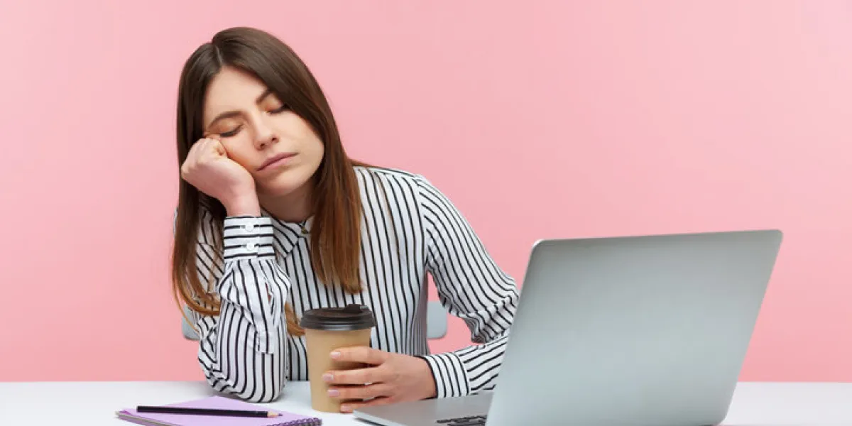 sleepy inefficient woman office worker napping leaning head on hand and holding coffee cup sitting at workplace with laptop, physical exhaustion indoor studio shot isolated on pink background sleepy inefficient woman office worker napping leaning head on hand and holding coffee cup sitting at workplace with laptop, physical exhaustion indoor studio shot isolated on pink background