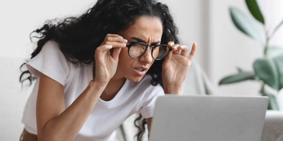 young woman freelancer with bad eyesight using laptop, using glasses, home interior, copy space curly lady holding her glasses and squinting, looking at laptop screen, having vision troubles