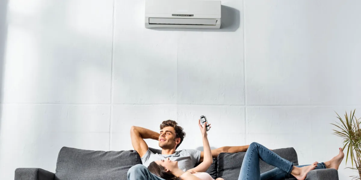 attractive girlfriend switching on air conditioner and lying on legs of handsome boyfriend attractive girlfriend switching on air conditioner and lying on legs of handsome boyfriend