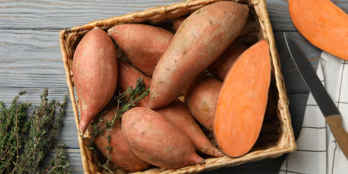 sweet potato in basket on wooden background, top view sweet potato in basket on wooden background, top view