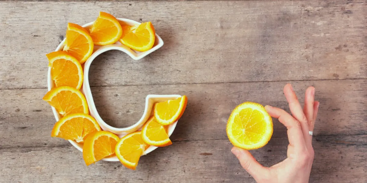 vitamin c or ascorbic acid nutrient in food concept plate in shape of letter c with orange slices and woman's hand with citrus making sign ok on wooden background flat lay or top view vitamin c or ascorbic acid nutrient in food concept plate in shape of letter c with orange slices and woman's hand with citrus making sign ok on wooden background flat lay or top view