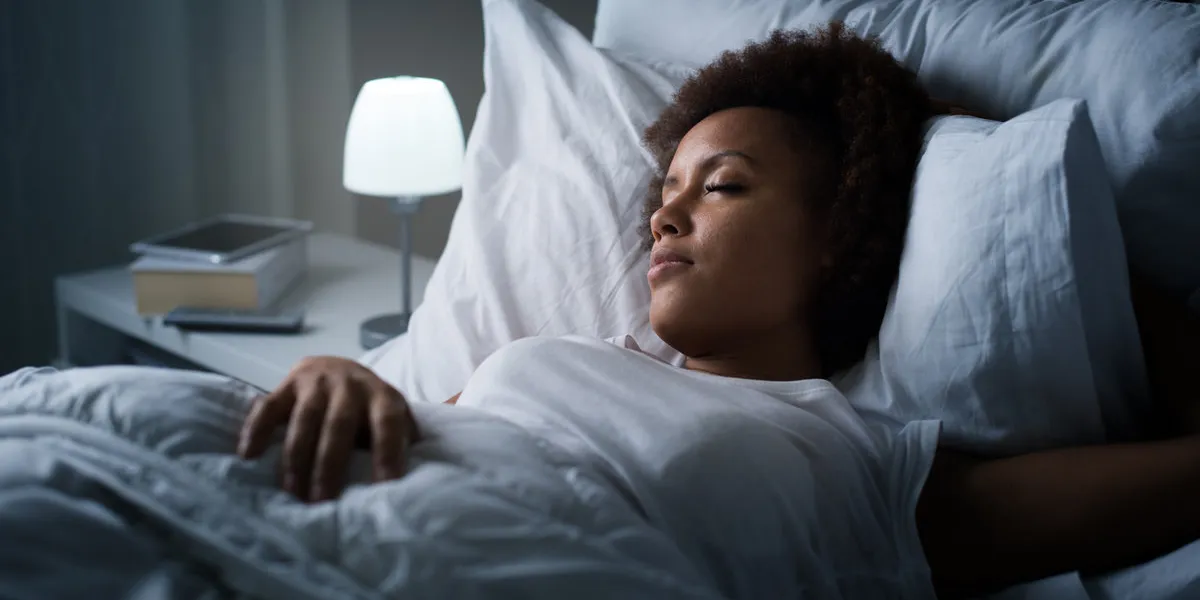 young mixed race woman sleeping in her bed at night, she is resting with eyes closed young mixed race woman sleeping in her bed at night, she is resting with eyes closed