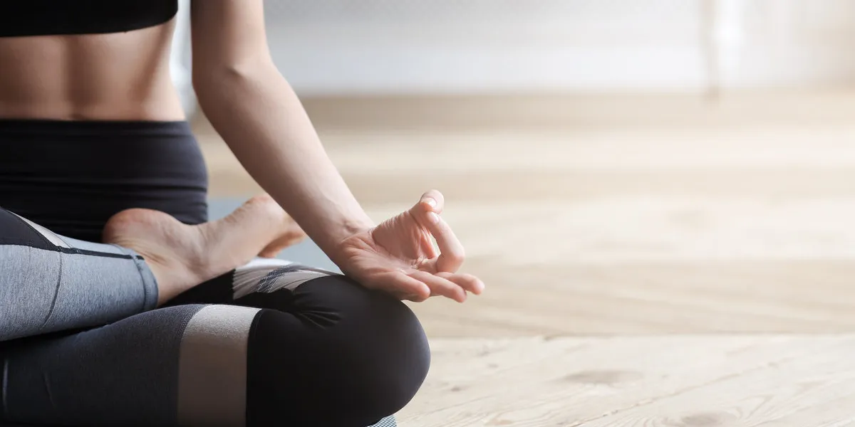 yoga, meditation, pilates concept close up of yoga woman sitting in lotus pose on wooden floor, copy space yoga, meditation, pilates concept close up of yoga woman sitting in lotus pose on wooden floor, copy space