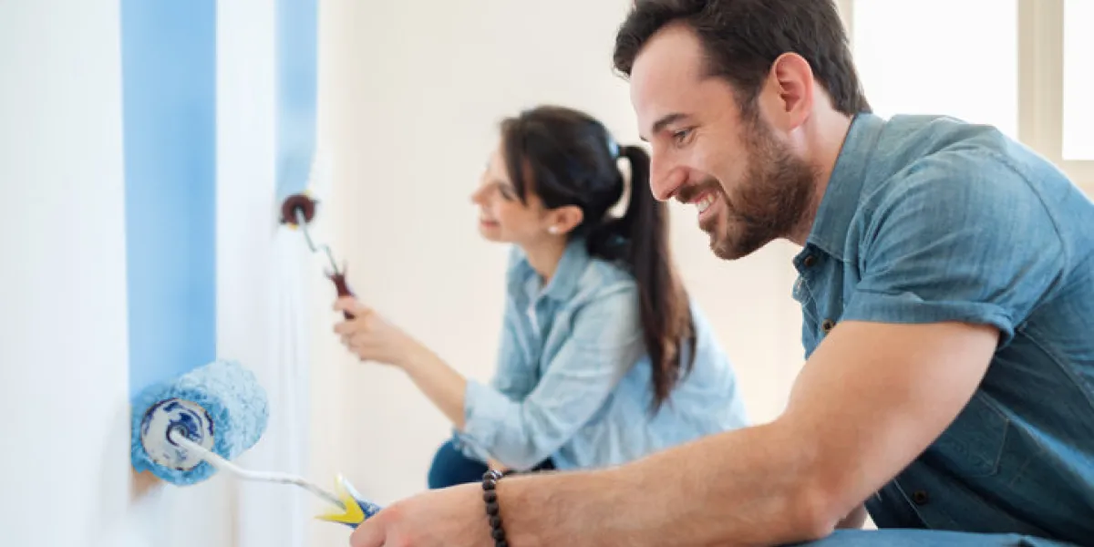 young couple painting walls in their new house, do it yourself concept young couple painting walls in their new house, do it yourself concept