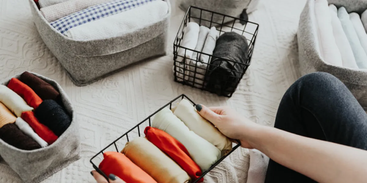 folding clothes and organizing stuff in boxes and baskets concept of tidiness, minimalist lifestyle and japanese t-shirt folding system folding clothes and organizing stuff in boxes and baskets concept of tidiness, minimalist lifestyle and japanese t-shirt folding system