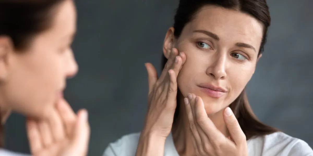 close up unhappy sad woman looking at red acne spots on chin in mirror, upset young female dissatisfied by unhealthy skin, touching, checking dry irritated face skin, skincare and treatment concept close up unhappy sad woman looking at red acne spots on chin in mirror, upset young female dissatisfied by unhealthy skin, touching, checking dry irritated face skin, skincare and treatment concept