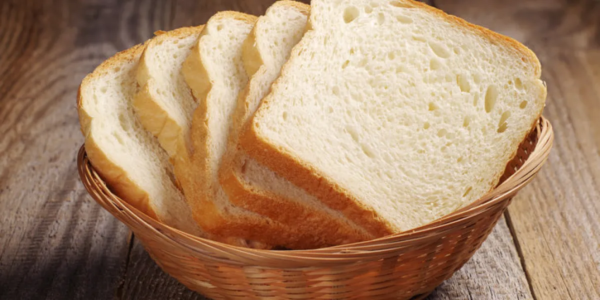 toast bread in wicker basket on old wooden table