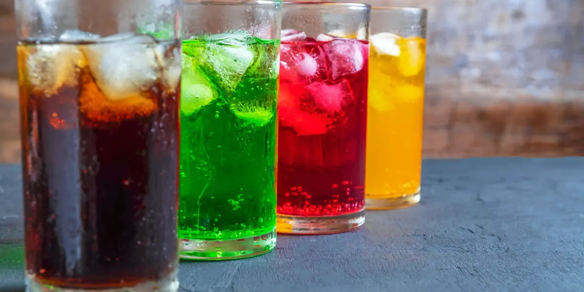 a lot of soft drinks in colorful and flavorful glasses on the table,glasses with sweet drinks with ice cubes