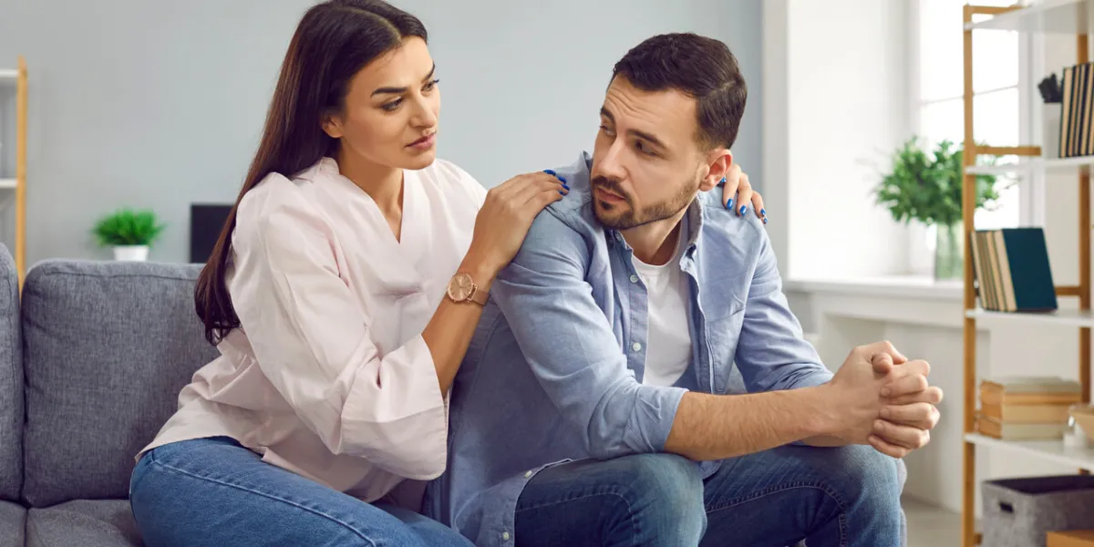 attractive wife hugging husband from back to comfort or apologize young woman hugging upset man, expressing understanding, saying sorry, showing support couple sitting on sofa at home attractive wife hugging husband from back to comfort or apologize young woman hugging upset man, expressing understanding, saying sorry, showing support couple sitting on sofa at home