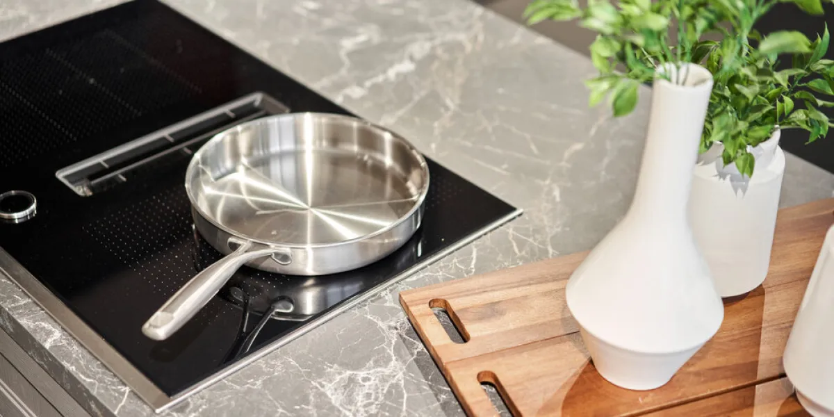 new cookware set on black induction hob in modern kitchen pot and frying pan in the kitchen on the hob cooking concept - close up of kitchen table with modern equipment new cookware set on black induction hob in modern kitchen pot and frying pan in the kitchen on the hob cooking concept - close up of kitchen table with modern equipment