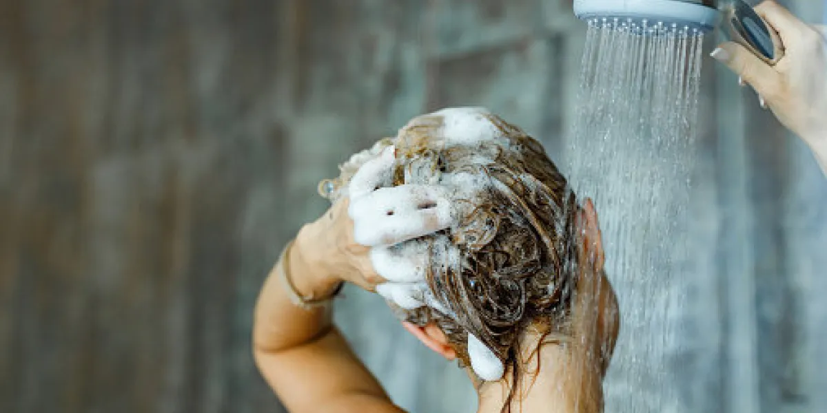 back view of a woman washing her hair with a shampoo in bathroom copy space back view of a woman washing her hair with a shampoo in bathroom copy space