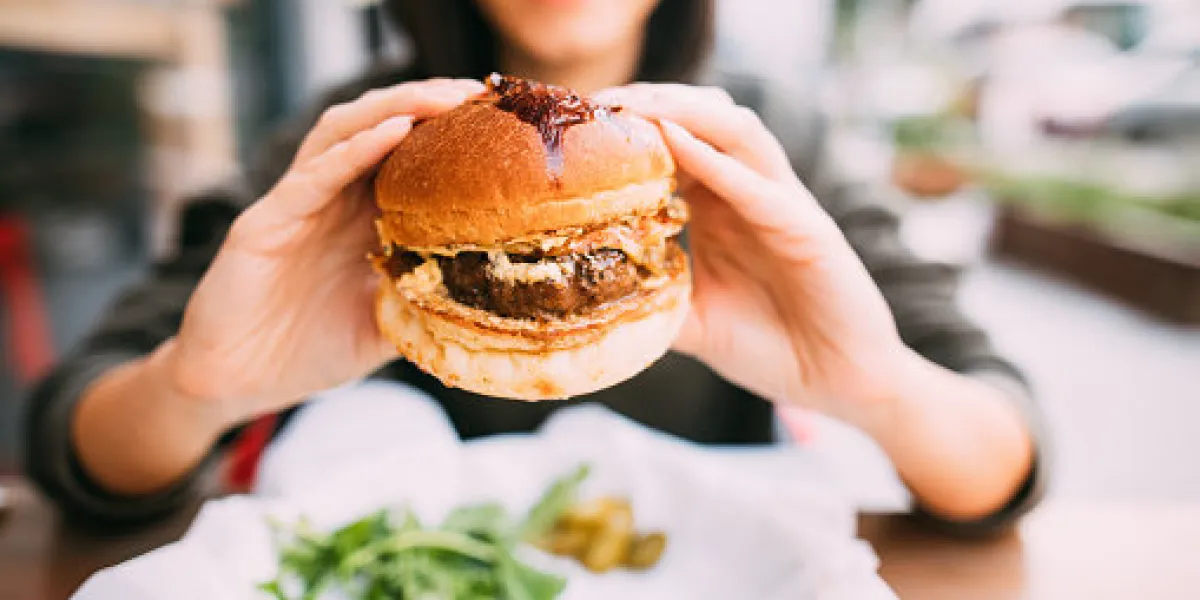 woman eating beef burger woman eating beef burger