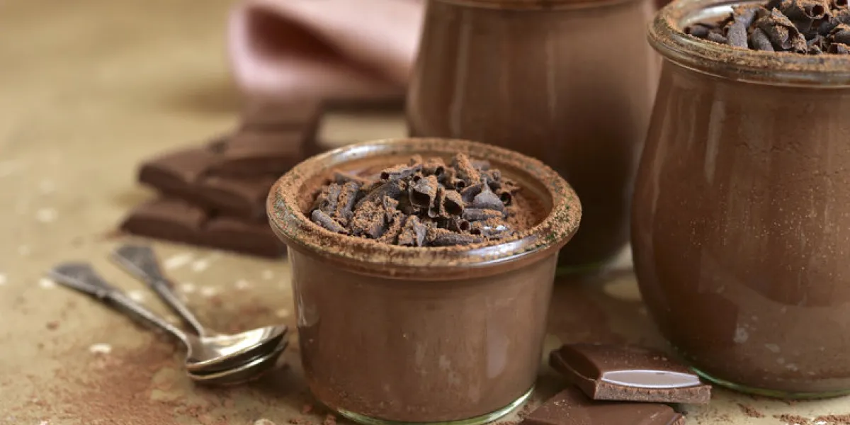 homemade chocolate pudding in a vintage glass jars on a beige slate, stone or concrete background homemade chocolate pudding in a vintage glass jars on a beige slate, stone or concrete background