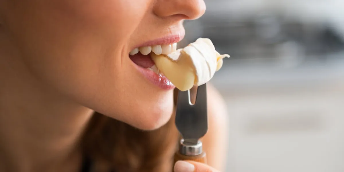 closeup on young woman eating camembert closeup on young woman eating camembert