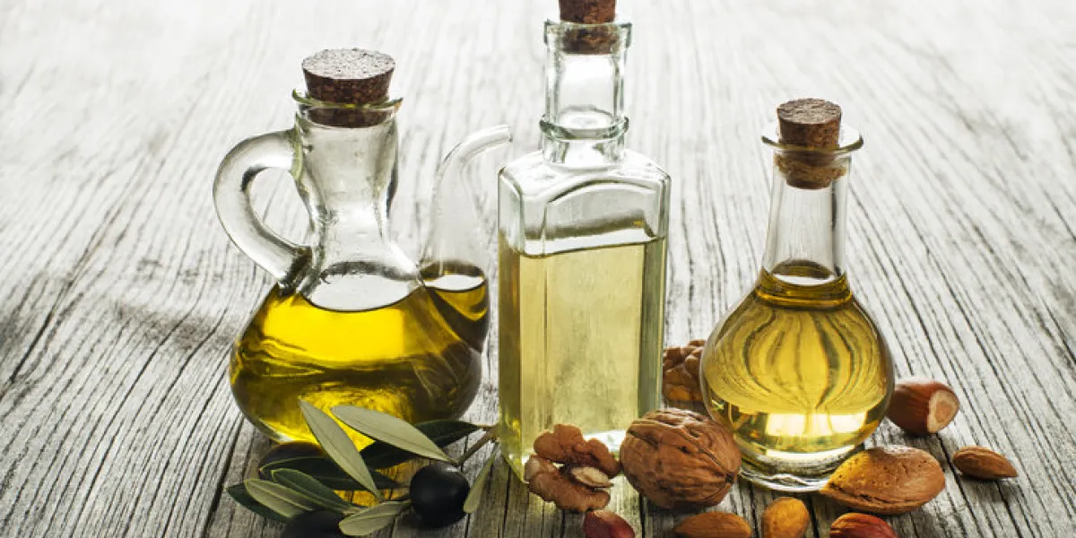 olive, walnut and almond oil on wooden background