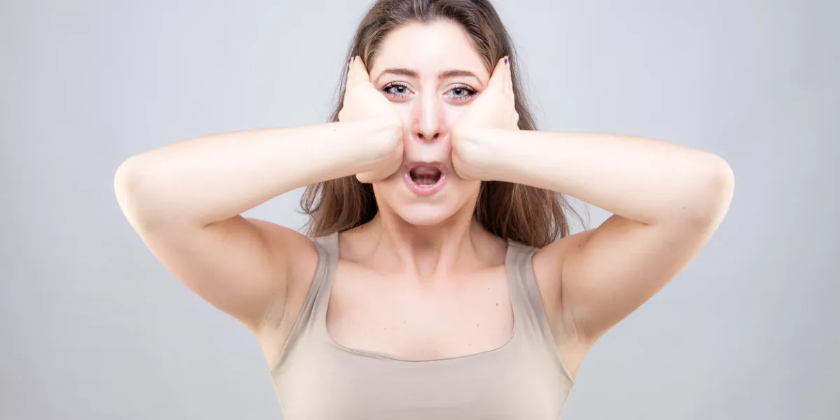 beautiful young caucasian woman doing face yoga pose