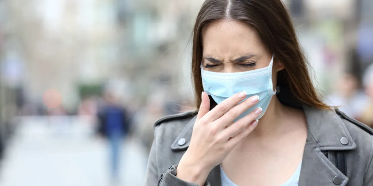 portrait of a sick woman with protective medical mask coughing on city street portrait of a sick woman with protective medical mask coughing on city street