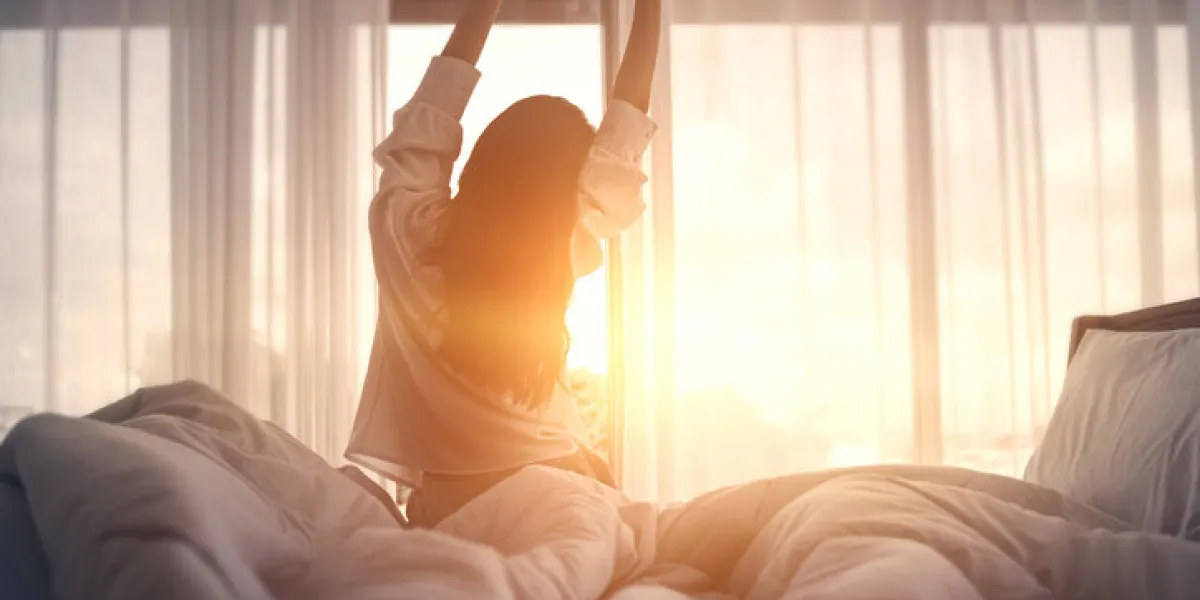 happy woman stretching in bed after waking up happy young girl greets good day