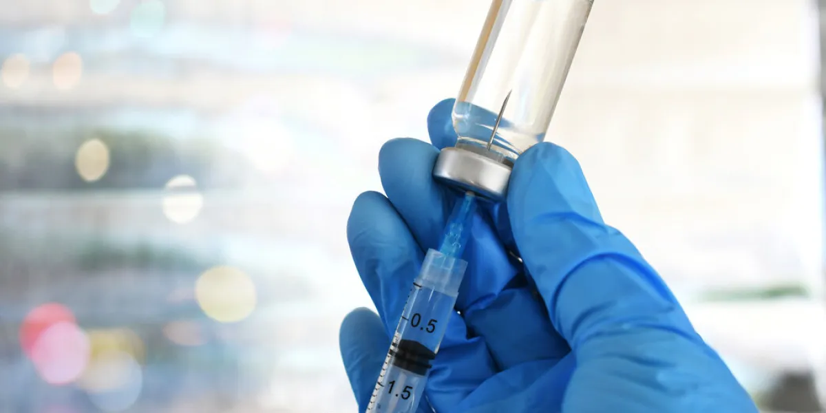 medical personnel filling a syringe needle with generic vaccine medical personnel filling a syringe needle with generic vaccine