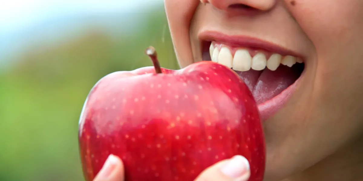 closeup of a mouth biting a red apple closeup of a mouth biting a red apple