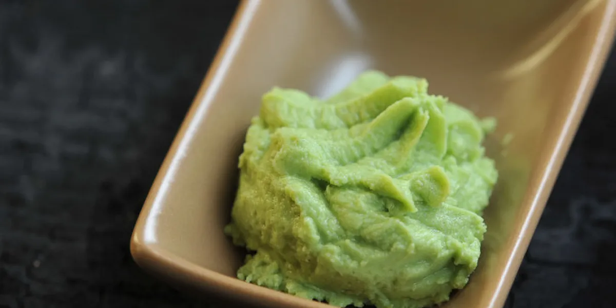 wasabi is a seasoning of japanese cuisine wasabi in a ceramic bowl dark background close-up macro shooting wasabi is a seasoning of japanese cuisine wasabi in a ceramic bowl dark background close-up macro shooting