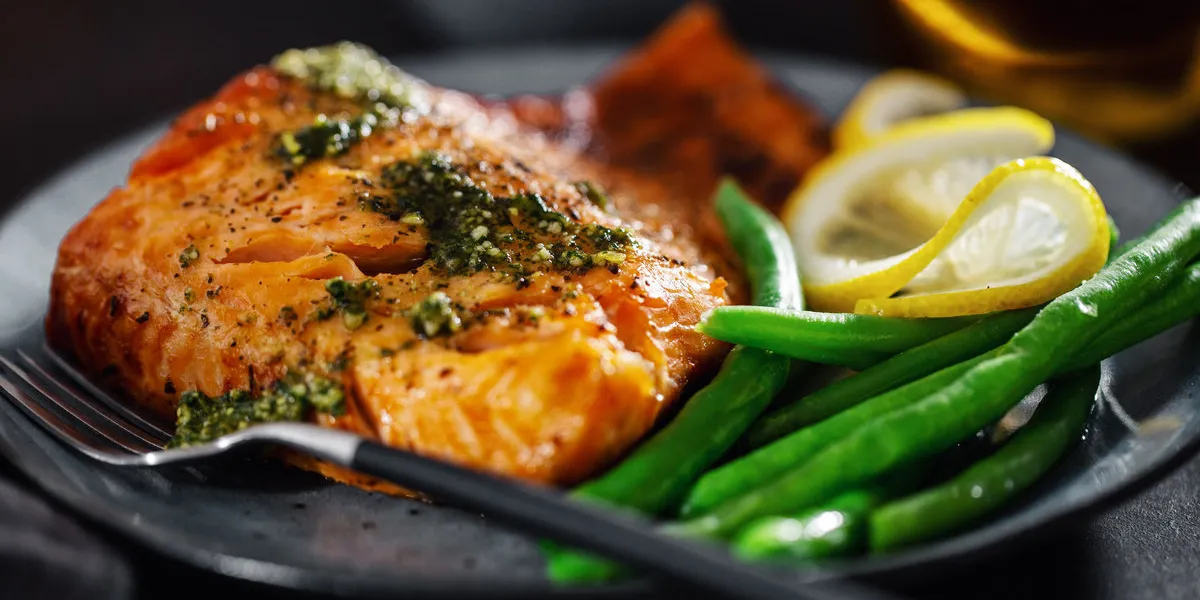 closeup of baked salmon fish with green beans on plate closeup of baked salmon fish with green beans on plate