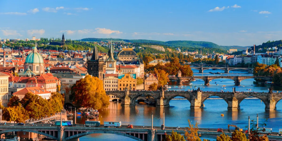 view of the vltava river and charle bridge with red foliage, prague, czech republic view of the vltava river and charle bridge with red foliage, prague, czech republic