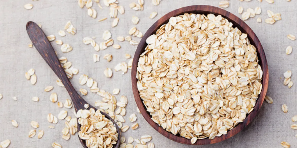 healthy breakfast organic oat flakes in a wooden bowl grey textile background top view copy space healthy breakfast organic oat flakes in a wooden bowl grey textile background top view copy space