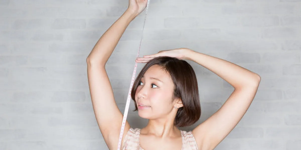 メジャーで身長を測るスタイルのいい女性 メジャーで身長を測るスタイルのいい女性