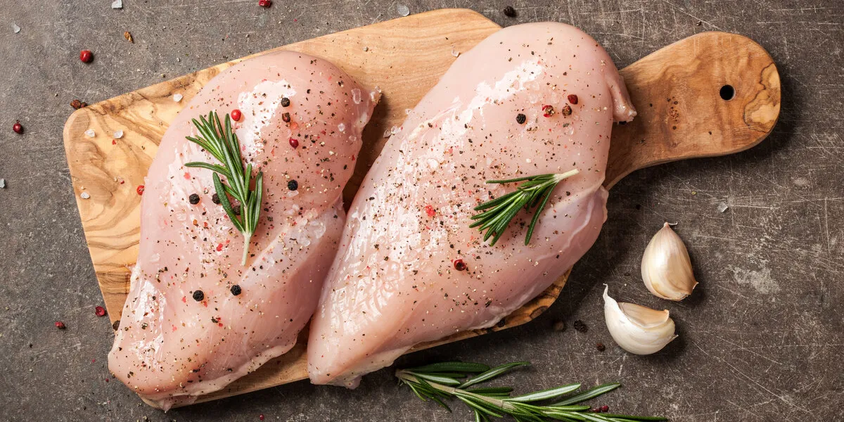 fresh chicken fillet with spices on cutting board