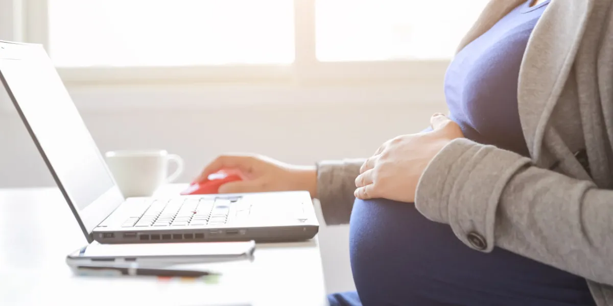pregnant woman is working on computer laptop and mobile phone, business