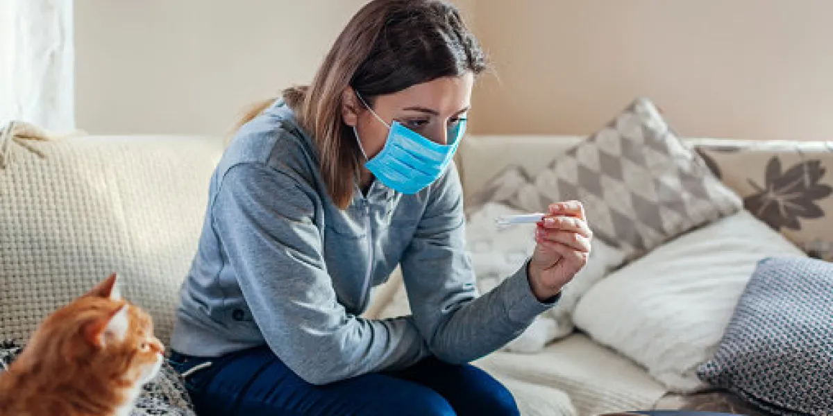 ill infected woman checking thermometer having fever girl wearing protective mask while having cold, flu taking pills at home healthcare ill infected woman checking thermometer having fever girl wearing protective mask while having cold, flu taking pills at home healthcare