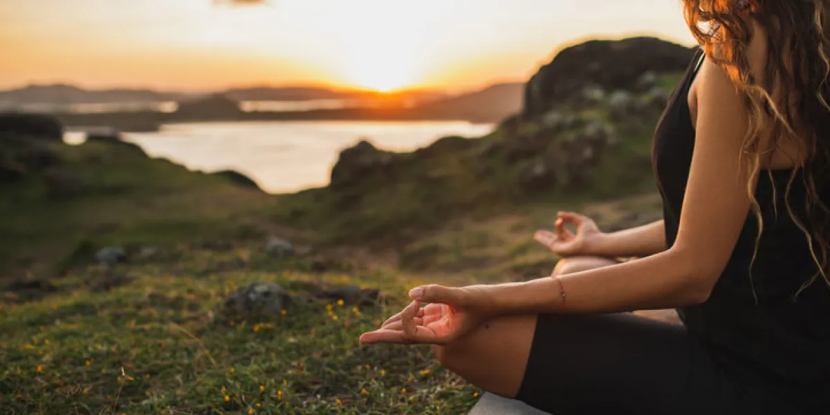 healthy lifestyle and yoga concept close-up hands woman do yoga outdoors at sunrise in lotus position woman exercising and meditating in morning nature background healthy lifestyle and yoga concept close-up hands woman do yoga outdoors at sunrise in lotus position woman exercising and meditating in morning nature background