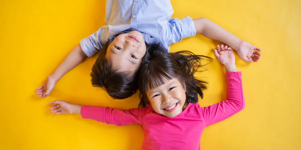 portrait of young happy little asian boy girl in on yellow background education for preschool toddler, brother and sister lifestyle back to school together concept portrait of young happy little asian boy girl in on yellow background education for preschool toddler, brother and sister lifestyle back to school together concept