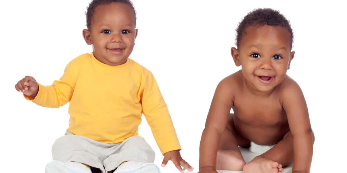 couple of twins sitting on the floor isolated on a white background couple of twins sitting on the floor isolated on a white background
