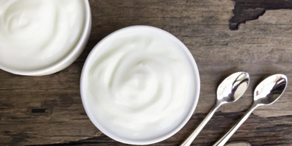 yogurt in white glass on wood background from the top view