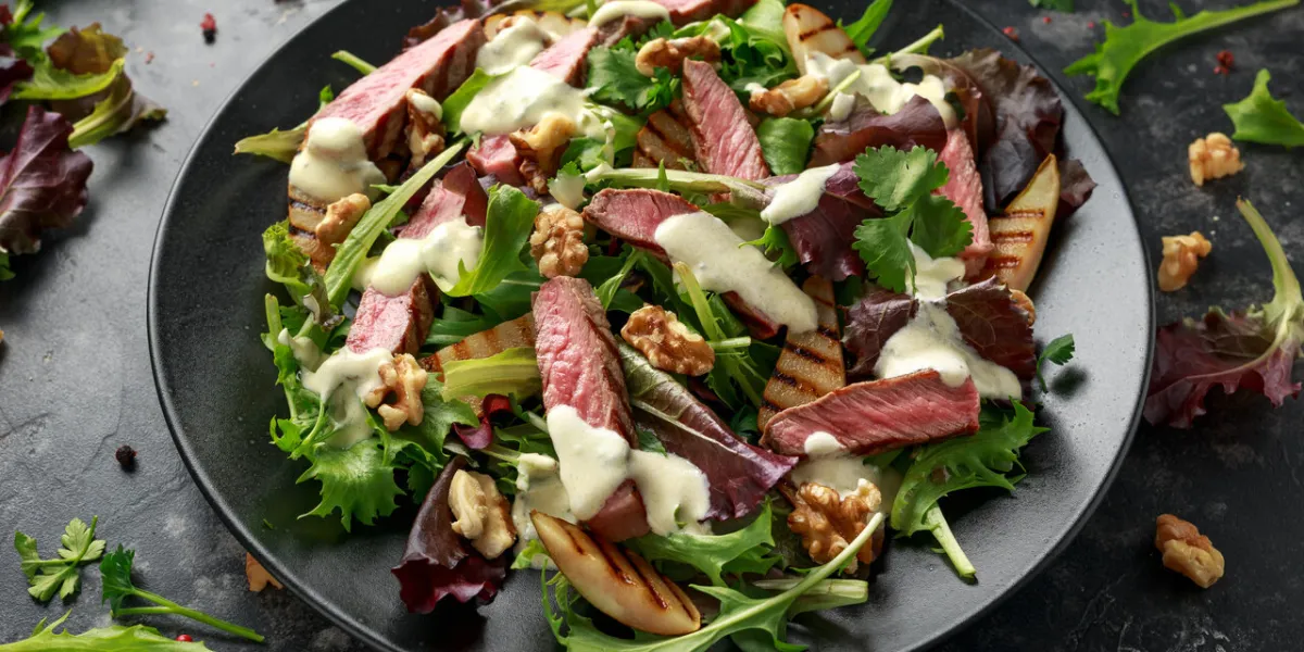 grilled beef steak salad with pears, walnuts and greens vegetables and blue cheese sauce healthy food grilled beef steak salad with pears, walnuts and greens vegetables and blue cheese sauce healthy food