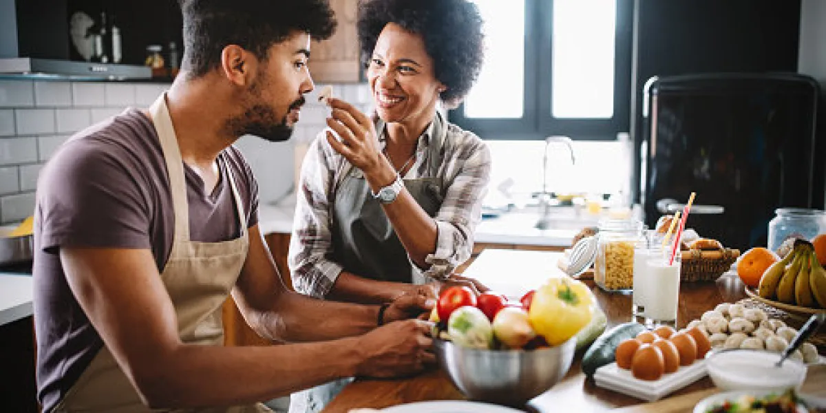 beautiful young couple having fun and laughing while cooking in kitchen at home beautiful young couple having fun and laughing while cooking in kitchen at home