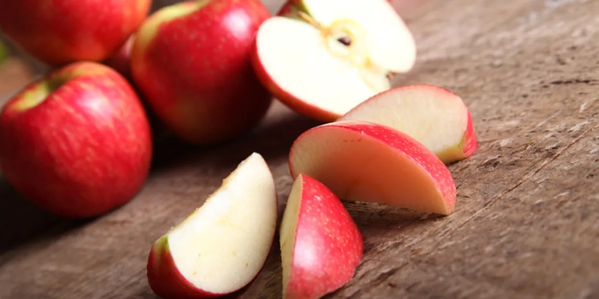 red apple and slices on barn wood