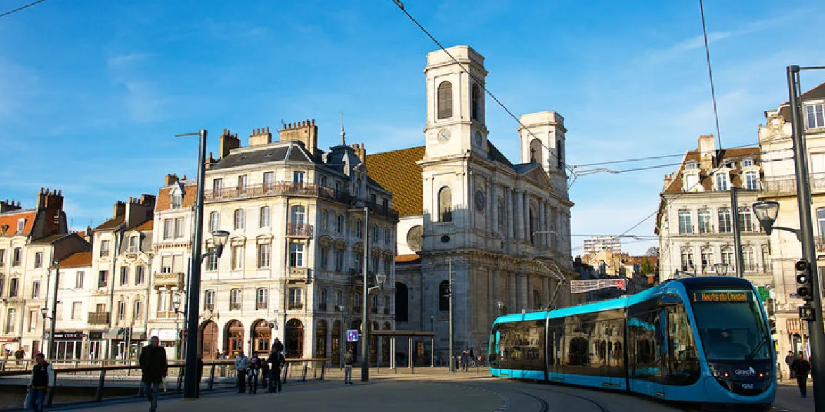 besançon,france-12 22 2014  a tramway is passing nearby the sainte madeleine church building in the city center of besançon in franche-comté, france