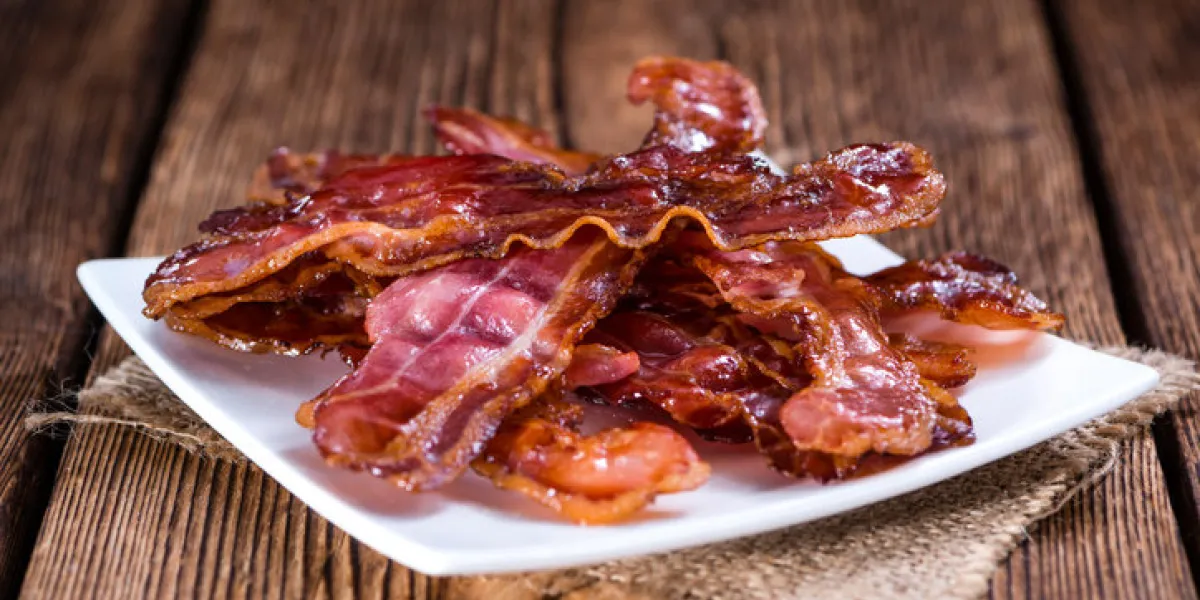 fried bacon (selective focus) on an old vintage wooden table fried bacon (selective focus) on an old vintage wooden table