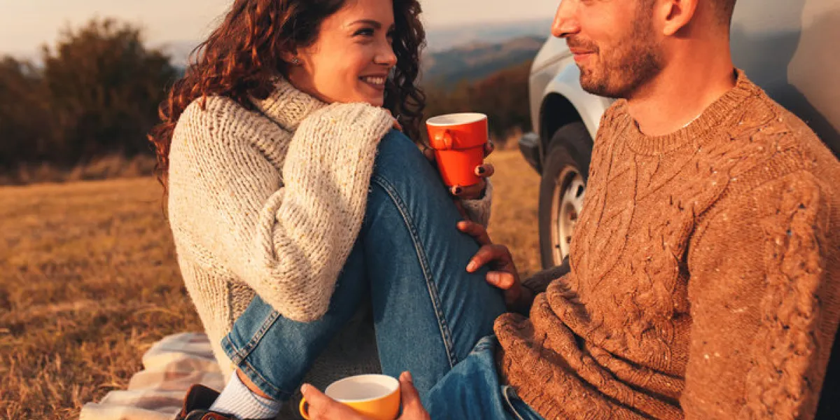 beautiful young couple enjoying picnic time on the sunset they drinking tea and sitting in a meadow leaning against a old fashioned car beautiful young couple enjoying picnic time on the sunset they drinking tea and sitting in a meadow leaning against a old fashioned car