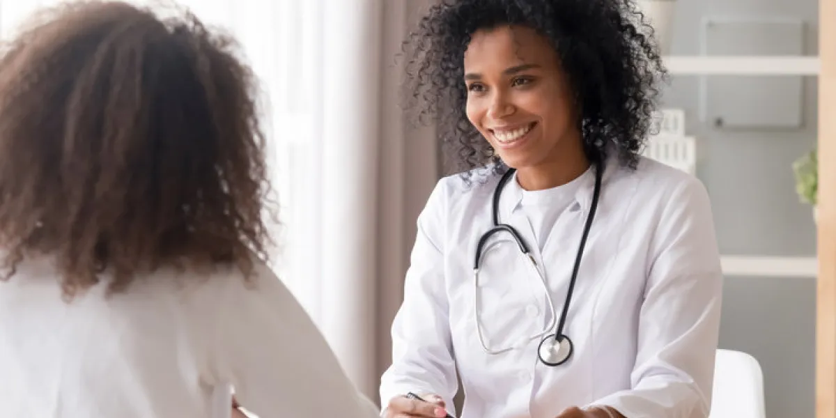 smiling african american female doctor talking to teen patient making notes in clipboard listening to black kid school teenage girl tell complaints fill form at medical clinic checkup appointment smiling african american female doctor talking to teen patient making notes in clipboard listening to black kid school teenage girl tell complaints fill form at medical clinic checkup appointment