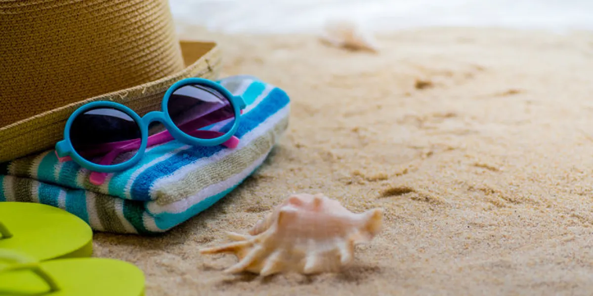 beach accessories on table on beach - summer holidays beach accessories on table on beach - summer holidays