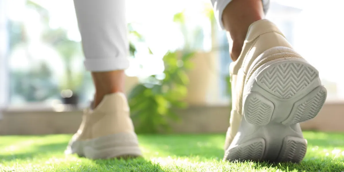 young woman wearing stylish sneakers on green grass, closeup young woman wearing stylish sneakers on green grass, closeup