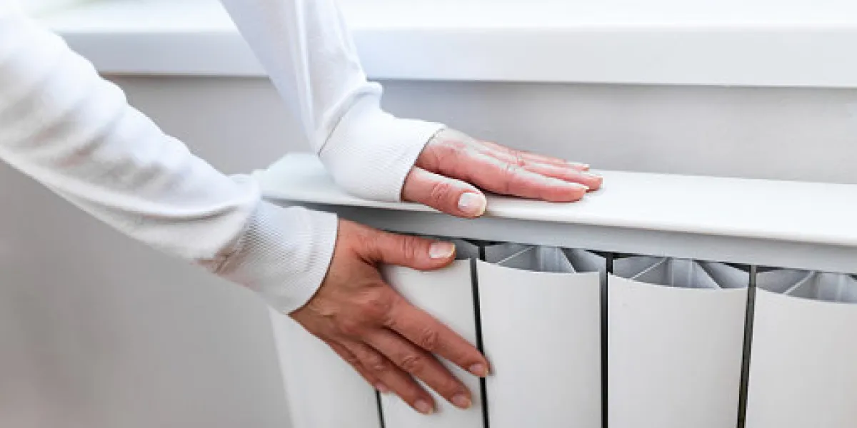 heavy duty radiator - central heating woman is getting her hands warm on home central heating system heavy duty radiator - central heating woman is getting her hands warm on home central heating system