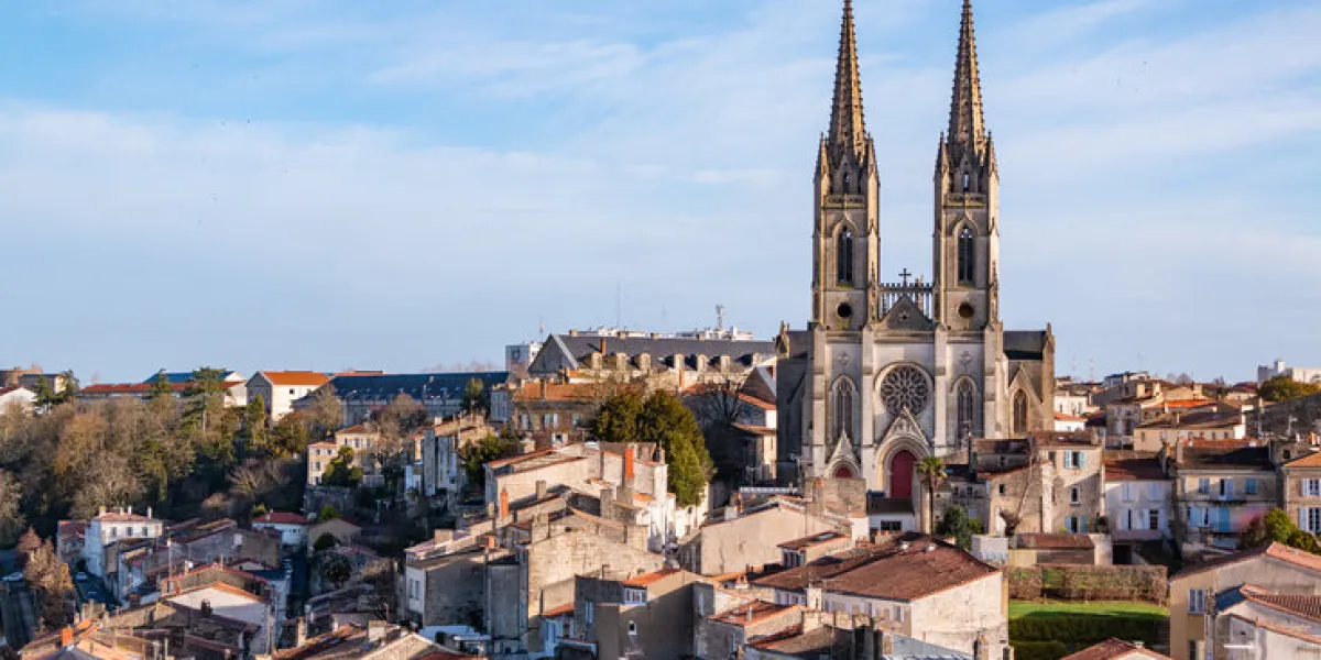 a picture of the saint andrew's church of niort towering the city
