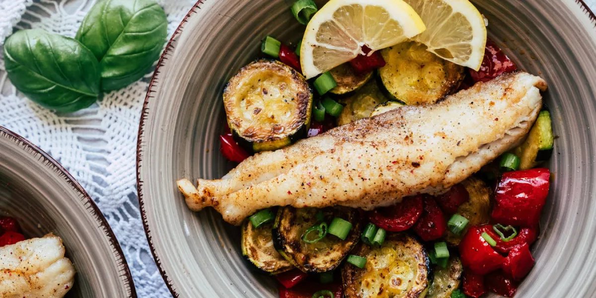 plat de poisson filet de colin accompagné de légumes courgette