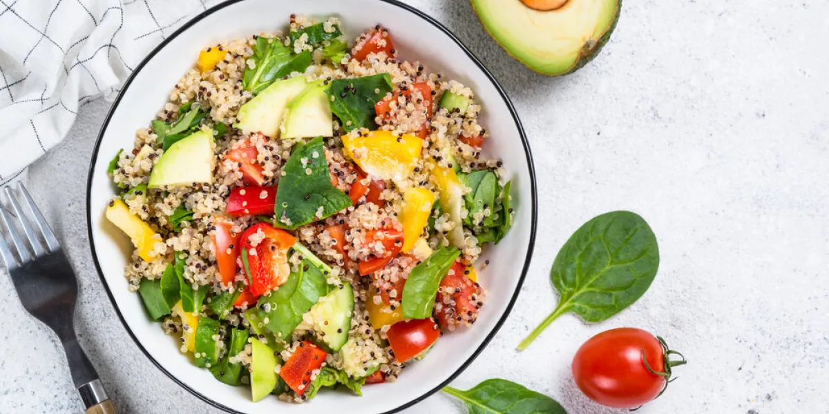 quinoa salad with spinach, avocado, paprika and tomatoes on white stone table top view with copy space quinoa salad with spinach, avocado, paprika and tomatoes on white stone table top view with copy space